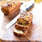 a loaf of bread sitting on top of a wooden cutting board next to a knife