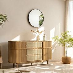 a living room with a round mirror on the wall next to a dresser and chair