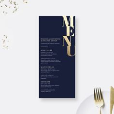 a menu with gold lettering on it next to a fork and knife