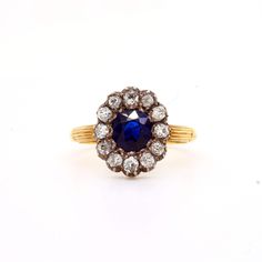 Victorian sapphire and diamond cluster ring mounted in silver and 18ct gold. English. Circa 1880. The central round cushion shaped Burmese sapphire surrounded by an old cut round diamond border. Total sapphire weight approximately 1.20cts. Ttoal diamond weight approximately 0.80cts Antique Oval Sapphire Ring With Single Cut Diamonds, Victorian Sapphire Ring With Oval Brilliant Cut, Heirloom Sapphire Diamond Ring With Rose Cut, Victorian Sapphire Ring With Diamond Oval Shape, Antique Sapphire Diamond Ring With Rose Cut, Antique Oval Sapphire Diamond Ring, Victorian Oval Sapphire Ring With Diamond, Antique Blue Diamond Ring With Rose Cut, Antique Oval Sapphire Ring With Rose Cut Diamonds