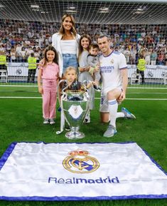 a group of people standing around a soccer trophy