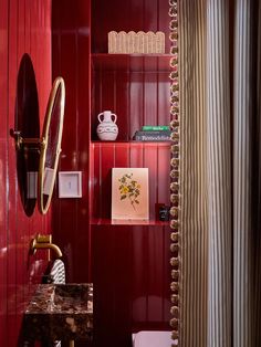 a bathroom with red walls and gold trim on the shower curtain is shown in this image