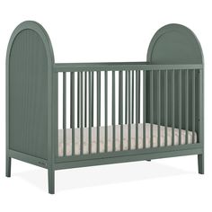 a green crib with a white mattress in the bottom half and an oval shaped headboard