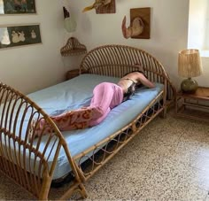 a woman laying on top of a bed in a room with pictures on the wall