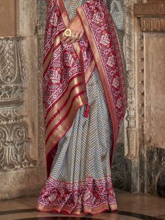 This grey silk saree is adorned with intricate zari patola print work. Embodying sophistication and grace, this saree is a testament to timeless beauty, perfect for adorning yourself during a multitude of occasions, from festive celebrations to intimate gatherings.
Accompanying this resplendent saree is a striking maroon silk blouse featuring matching patola print work. The bold contrast between the subtle grey saree and the vibrant maroon blouse adds a touch of drama and allure to the ensemble, Pre-draped Saree With Printed Border For Festive Occasions, Bollywood Style Gray Semi-stitched Traditional Wear, Elegant Bandhani Print Pre-draped Saree For Festive Occasions, Elegant Festive Pre-draped Saree With Bandhani Print, Elegant Festive Pre-draped Bandhani Saree, Gray Traditional Wear For Festive Occasions, Gray Festive Traditional Wear, Festive Gray Traditional Wear, Semi-stitched Gray Traditional Wear With Zari Work