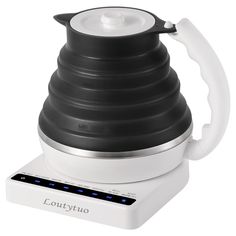 a black and white coffee pot sitting on top of a counter next to a charger