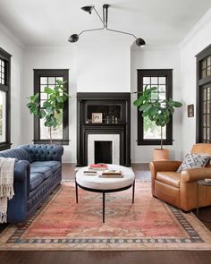 a living room with two couches, chairs and a rug in front of the fireplace