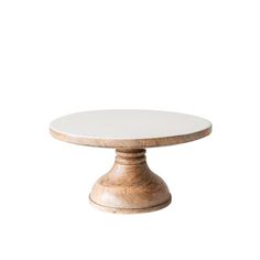 a white cake plate sitting on top of a wooden table