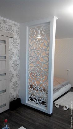 a room with a bed, dresser and closets in the corner that has white wallpaper on it