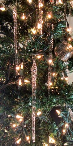 a close up of a christmas tree with lights on it and ornaments hanging from the branches