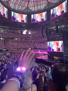 a person holding their hand up in front of a large crowd at a sporting event