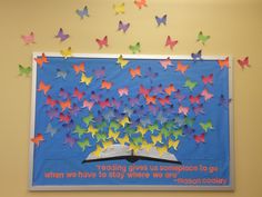 a bulletin board with colorful butterflies on it and a book in the middle that says reading gives us someplace to go