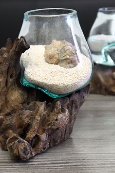 a glass vase filled with sand on top of a wooden table