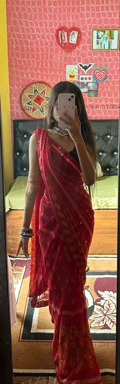 a woman in a red sari taking a selfie