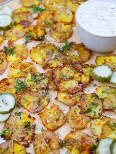 a pizza topped with lots of veggies next to a bowl of ranch dressing