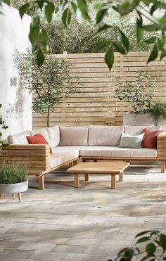 an outdoor living area with wooden furniture and plants