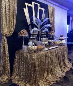 the table is covered with gold sequins and cupcakes for an event