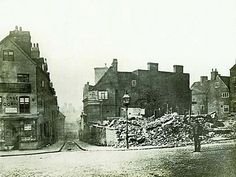 an old black and white photo of a street with buildings in the backgroud