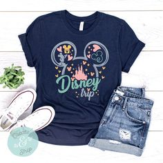 a mickey mouse shirt with the words disney trip on it next to some denim shorts