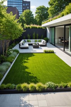 an outdoor living area with grass, couches and trees