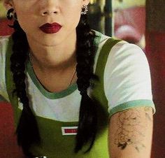 a woman with braids and tattoos sitting at a table