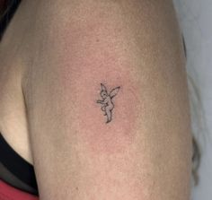 a small tattoo on the back of a woman's left arm, with a little fairy