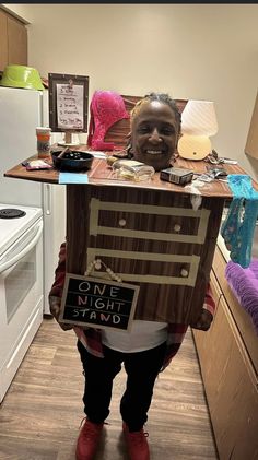 a person standing in a kitchen with a cardboard box on their head that is shaped like a computer