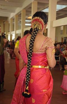 a woman in a red and gold sari with her back turned to the camera