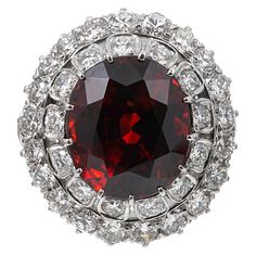 A beautiful cocktail ring with tiered rows of diamonds celebrating a large faceted oval spessartite garnet, the mounting made of platinum and decorated with approximately 4.00 carats of brilliant white diamonds. The major center stone weighs 18.14 carats and is described by the accompanying GIA report as exhibiting transparent orange-red color. It is, indeed, an impressive stone rich, royally-hued gem! Note thebeautifully finished shoulders, allowing this ring to be appreciated from every angle. Sapphire Cocktail Ring, Pink Garnet, 14k White Gold Diamond Ring, Garnet And Diamond Ring, Cognac Diamonds, Almandine Garnet, Spessartite Garnet, Diamond Cocktail Ring, Hessonite Garnet