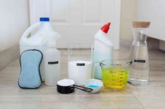 various cleaning supplies sitting on the floor next to each other