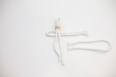 two white ropes tied to each other on top of a white surface with an object in the middle