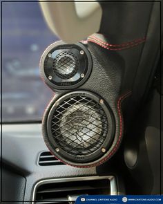 the interior of a car with two speakers in it's center console and an air vent