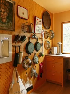 a kitchen wall with pots and pans hanging on it