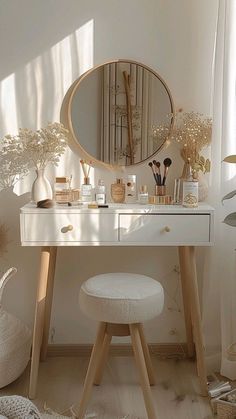 a white dressing table with a round mirror and stool in the corner next to it