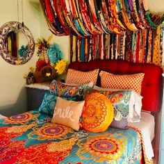 a bed covered in lots of colorful pillows