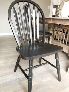 a black wooden chair sitting on top of a hard wood floor