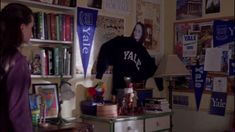 a woman standing in front of a room filled with books