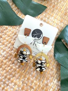 Introducing our stunning Geometric Dangle Earrings – a fusion of earthy elegance and bohemian flair that will add a touch of artistry to your ensemble! 🌿✨Crafted with creativity and care, these earrings feature mesmerizing mussel shell half moon connectors, exuding natural beauty and coastal charm. Paired with brass arches, wood posts, 5mm wood beads, and Kenyan polka dot bone saucer beads, these earrings boast a captivating blend of textures and tones, from warm browns and rich golds to crisp Brown Brass Drop Earrings, Handmade Earthy Teardrop Earrings, Handmade Teardrop Earthy Earrings, Brown Dangle Earrings With Artsy Style, Brown Artsy Earrings, Unique Brown Teardrop Earrings, Adjustable Earthy Dangle Earrings, Artisan Single Drop Earring, Artsy Brown Earrings With Ear Wire