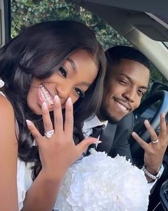 a man and woman sitting in a car with their hands on the bride's finger