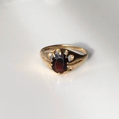 A vintage 9 carat yellow gold Garnet ring. This beautiful piece holds a gorgeous deep red stone in a snug setting, really letting that light bounce back through the stone.  CONDITION: Wear consistent with age and use. Face of stone has some wear. Please see photos for more detail. HALLMARKED 9 CARAT GOLD, ASSAYED IN BIRMINGHAM  STONE SIZE: 9mm x 7mm BAND WIDTH (NARROWEST): 2mm STONE AND SETTING HEIGHT: 5mm RING SIZE: UK: U | US: 10 WEIGHT: 2.5 grams Classic Ruby Ring With Polished Finish For Collectors, Vintage Ruby Rings With Polished Finish, Antique Ruby Rings With Polished Finish, Vintage 14k Gold Ruby Ring With Polished Finish, Antique Yellow Gold Ruby Ring With Polished Finish, Classic Oval Ruby Ring, Classic Red Signet Ring For Formal Occasions, Heirloom Ruby Signet Ring With Hallmark, Vintage Oval Garnet Birthstone Ring