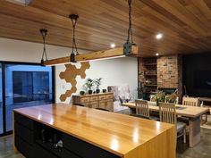 a kitchen and dining room area with wooden floors, exposed ceiling beams and large sliding glass doors