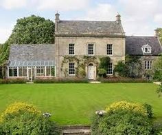 a large house with many windows and lots of greenery