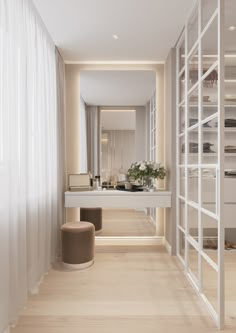 an empty bathroom with white walls and wooden flooring, along with a large mirror on the wall