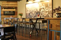 an empty restaurant with tables and chairs in front of a large painting on the wall