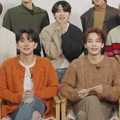 the group of young men are sitting in chairs and posing for a photo with their hands together