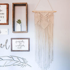 Macrame wall hanging in a boho gallery wall in a bedroom surrounded by wooden shelves and wood signed Gallery Wall In Bedroom, Boho Gallery Wall