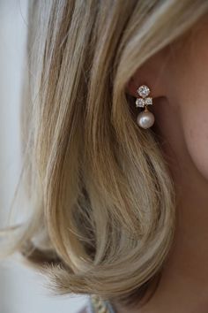 a close up of a person wearing some kind of earring with pearls on it