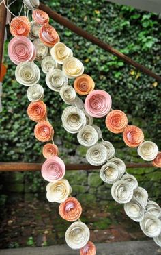 paper flowers are hanging from a wooden fence