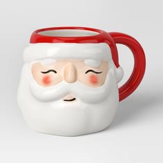 a red and white mug with a santa face on it