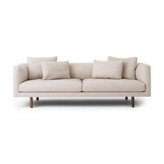 a white couch with four pillows on it's back and one arm extended to the side